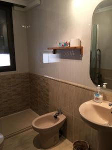 a bathroom with a sink and a toilet and a mirror at Apartamentos Arcos Céntrico in Águilas