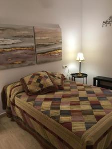 アギラスにあるApartamentos Arcos Céntricoのベッドルーム1室(ベッド1台付)が備わります。壁には絵画2点が飾られています。