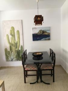 una mesa negra y sillas en una habitación con pinturas en Apartamentos Arcos Céntrico, en Águilas
