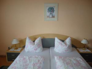 1 dormitorio con 2 camas con almohadas y 2 lámparas en Ferienwohnungen Salzwedel Weissbach, en Salzwedel