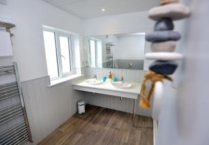 La salle de bains est pourvue de 2 lavabos et d'un grand miroir. dans l'établissement Mevagissey Bay Hotel, à Mevagissey