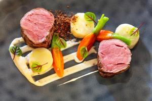 um prato de alimentos com carne e legumes sobre ele em Hôtel Carcarille Restaurant Le C em Gordes