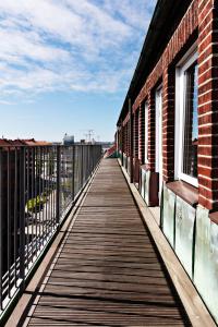 eine hölzerne Promenade, die zu einem Gebäude mit Fenstern führt in der Unterkunft Sure Hotel by Best Western Arena in Göteborg