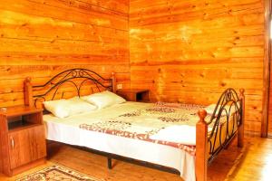 a bedroom with a bed in a log cabin at Guest house Sirius in Pizunda