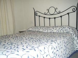 a bed with a white comforter and two pillows at Hostal Muriel in Aljaraque