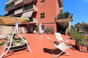 2 sedie e un ombrellone su un patio di La Terrazza Parco Lauro Apartment a Sorrento