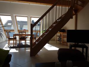 a staircase in a living room with a table and a television at Ferienwohnung Reblaus in Rüdesheim am Rhein