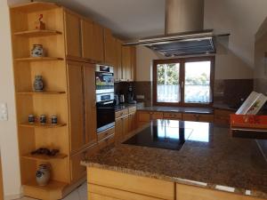 a kitchen with wooden cabinets and a black counter top at Ferienwohnung Reblaus in Rüdesheim am Rhein