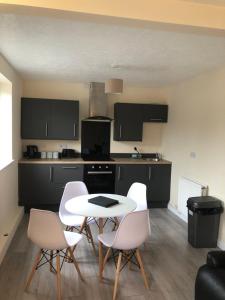 a kitchen with a table and white chairs in a room at Highgate Inn Hotel in Pembroke