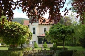 une grande maison blanche avec un toit rouge dans l'établissement Glögglhof, à Trofaiach