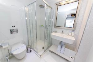 a bathroom with a shower and a sink and a toilet at Demi Hotel in Sarandë