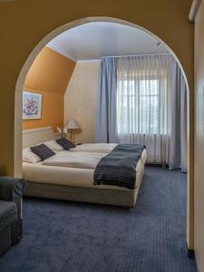 a bedroom with a large bed in an archway at Hotel Pontivy in Wesseling