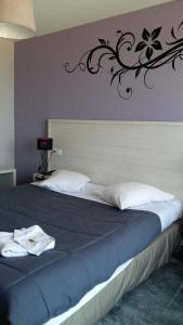 ein Schlafzimmer mit einem großen Bett mit schwarzer Dekoration an der Wand in der Unterkunft Hotel des Thermes et du Casino in Luc-sur-Mer + 49 Fotos