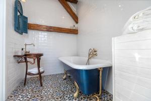 a bathroom with a blue tub and a sink at Casa Carolina Brasov in Braşov +35 photos