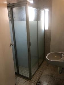 W łazience znajduje się szklana kabina prysznicowa i umywalka. w obiekcie Espacios de Pando w mieście Puebla