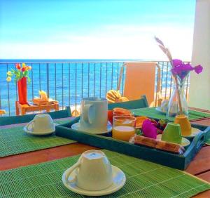 uma mesa com uma bandeja de comida e vista para o oceano em Le Terrazze di Apollo - Case Tilotta em Marinella di Selinunte