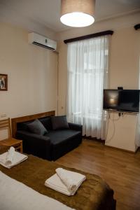 a living room with a black couch and a television at Tbilisi Apartment 2 in Tbilisi City