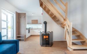 a living room with a fireplace and a staircase at Lubiatowe Love - domki w otulinie lasu in Lubiatowo