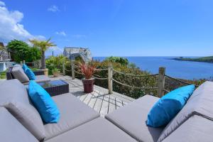 um pátio com almofadas azuis e vista para o oceano em Mevagissey Bay Hotel em Mevagissey