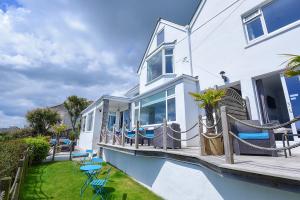 a white house with a deck with chairs at Mevagissey Bay Hotel in Mevagissey