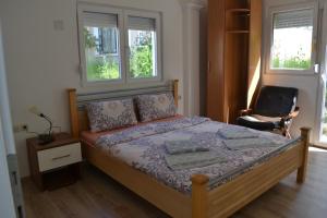 a bedroom with a bed and two windows at Apartments Center in Ohrid