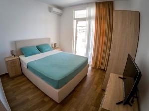 Un dormitorio con una cama grande y una ventana en Queen Apartments & Rooms, en Dobra Voda