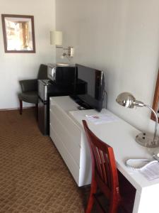 a hotel room with a desk with a computer on it at Dutch Cup Motel in Sultan