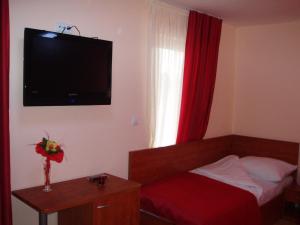 Habitación de hotel con cama y TV en la pared en Hotel Jezero, en Sarajevo