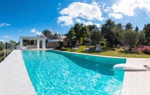 a swimming pool with a view of a villa at Trulli Santa Maria dei Grani - Authentic Puglia Trulli with Private Pool & Scenic Garden in Ceglie Messapica