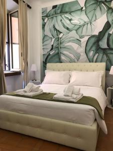 sypialnia z dużym łóżkiem z malowidłem kwiatowym w obiekcie Colosseo Smart Flat w Rzymie