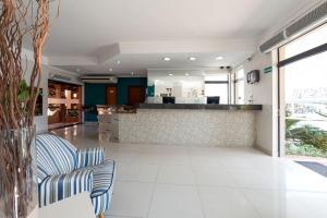 a lobby with two chairs and a bar at Verona Hotel in Limeira