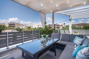 a patio with a couch and a table on a balcony at Villa Iceberg in Kalamaki Heraklion