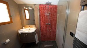 uma casa de banho com um chuveiro vermelho e um lavatório. em Mas des Avelines em Le Castellet