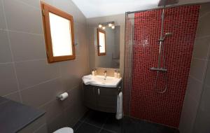 a bathroom with a sink and a shower with red tiles at Mas des Avelines in Le Castellet