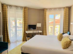 a bedroom with a large bed and a television at Hotel Amiraute in Cannes