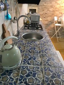 a kitchen counter with a sink and a stove at Il Sipario Palazzo Accolla in Siracusa