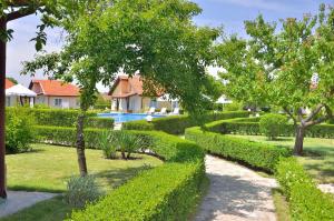 einen Garten mit Hecken und einem Pool in der Unterkunft Sunny Hills Villas in Bryastovets