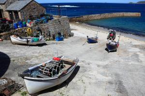 a group of boats sitting on the beach at The Old Success Inn in Sennen Cove