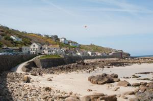 a beach with a bunch of birds on the sand at The Old Success Inn in Sennen Cove