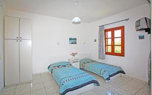 a bedroom with two beds and a window at Villa Maro in Skopelos Town