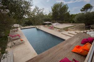 uma piscina com um deque, cadeiras e mesas em Mas des Avelines em Le Castellet