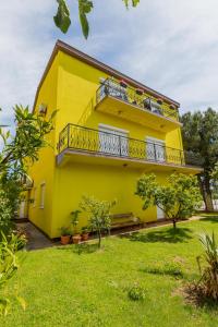 żółty dom z balkonem i dziedzińcem w obiekcie Apartment Mery w Puli