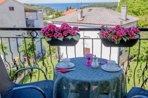 a blue table with flowers on a balcony at Apartment Mery in Pula