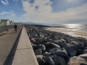a man and a child riding bikes on the beach at Park Home at Golden Sands Holiday Park in Foryd