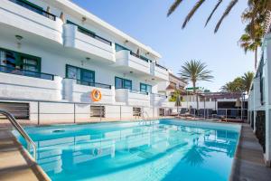 a swimming pool in front of a building at Apartamentos Olympia in Playa del Ingles +11 photos