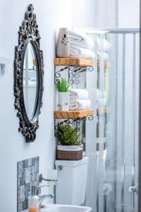 a bathroom with a toilet and a mirror and towels at Villa Iceberg Mini in Kalamaki Heraklion