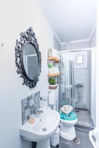 a bathroom with a toilet and a sink and a mirror at Villa Iceberg Mini in Kalamaki Heraklion