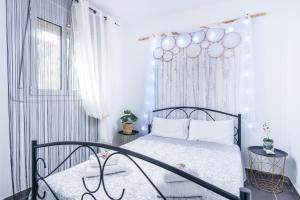a white bedroom with a bed and a window at Villa Iceberg Mini in Kalamaki Heraklion