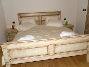 un grande letto in legno con due cuscini sopra di Agroturism Stara Štala a Borut