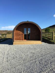 a small wooden building on a gravel road at Glenview Lodge in Portree